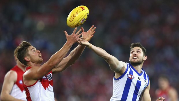 North Melbourne's Aaron Black competes for the ball with Sydney's Dane Rampe.