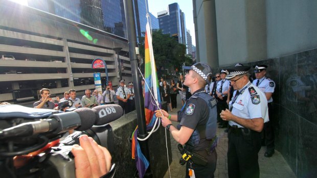 Transgender police officer Mairead Devlin raises the rainbow flag for the first time outside QPS headquarters.