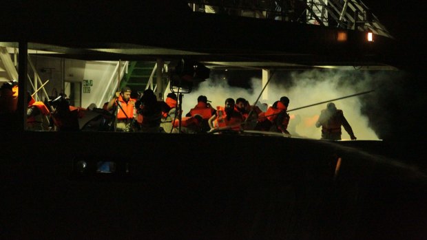 Passengers on the Mavi Marmara run as tear gas is fired by Israeli commandos.