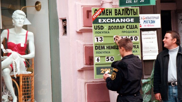 A bank official puts a new exchange rate outside an exchange booth in Moscow during the 1998 crisis.  