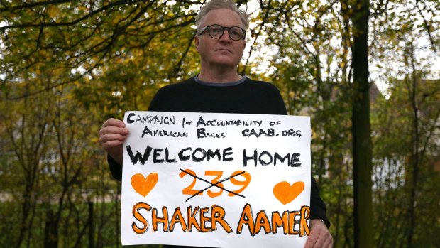 A supporter holds a placard after Shaker Aamer arrived at Biggin Hill Airport, England, on Friday.