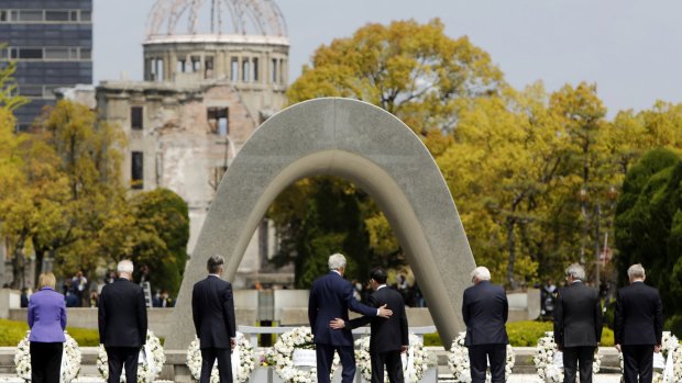 US Secretary of State John Kerry, fourth from left, puts his arm around Japanese Foreign Minister Fumio Kishida after G7 foreign ministers laid wreaths at Hiroshima Peace Memorial Park last month. The bombed movie theatre is seen in the background.
