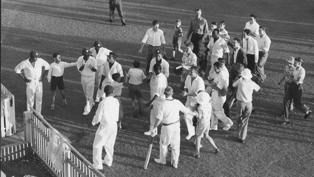 Players move to the gate leading to the dressing pavillion after the Tied Test at the Gabba.  Australian Captain Richie Benaud had raced onto the field to shake hands and congratulate West Indies Captain Frank Worrell.