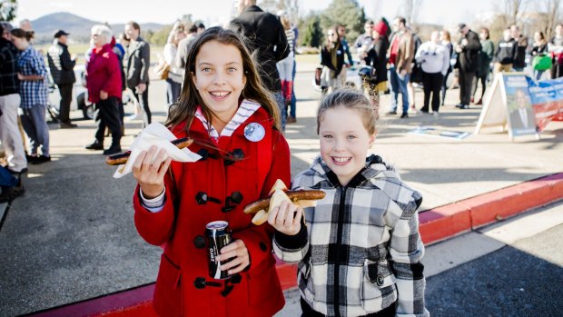 Tabatha Fachin 11, and her sister Chiara 9, of Brisbane enjoying the sausage sizzle at Old Parliament House on election day.