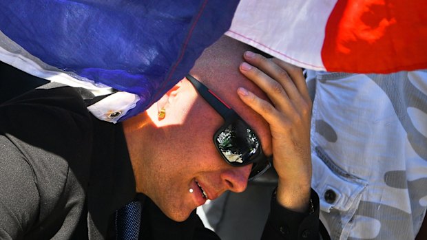 A man reacts as people visit the scene and lay tributes to the victims on the Promenade des Anglais in Nice.