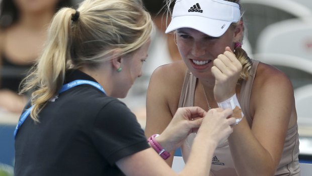 Caroline Wozniacki has her wrist taped by a trainer during a break in her match against Barbora Zahlavova Strycova.