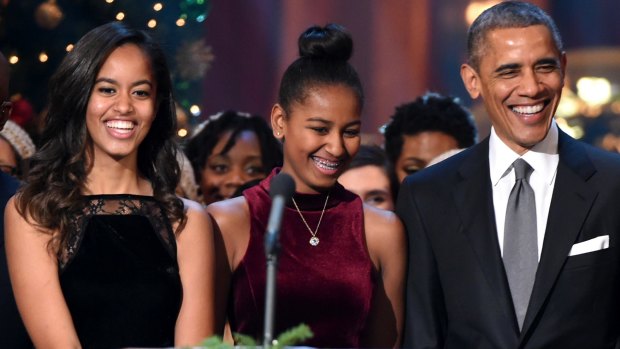Malia and Sasha Obama with their father in Washington at Christmas,  2014.