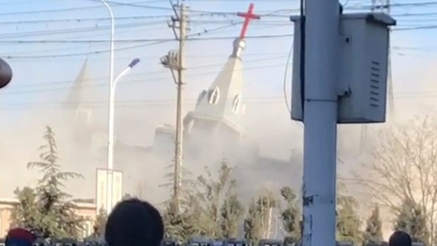 People watch the demolition of the Golden Lampstand Church in Linfen. Activists says the church had clashed with the government. 