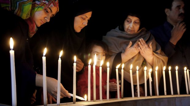 Pakistani women light candles during a vigil in Peshawar for victims of Wednesday's attack at Bacha Khan University.