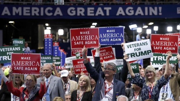 Delegates hold up signs and cheer during first day of the Republican National Convention.