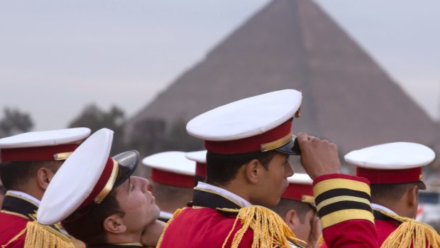 Honour guards prepare to welcome the ancient statue of Egyptian pharaoh Ramses II, at the entrance of the Grand Egyptian Museum, under construction near the Pyramids of Giza.