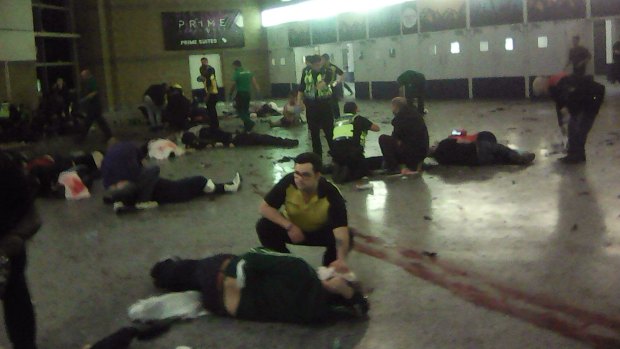 Helpers attend to injured people inside the Manchester Arena after Monday's blast.