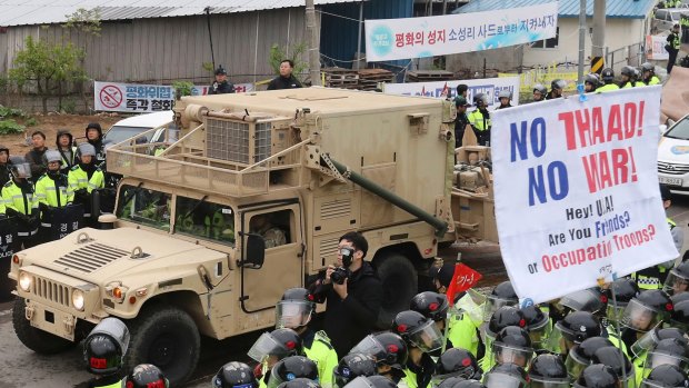 A US military vehicle in South Korea moves past protesters opposed to the THAAD missile defence system.