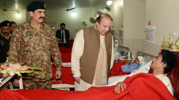 High level: Pakistani Prime Minister Nawaz Sharif and army chief Raheel Sharif visit a student injured in the Peshawar school massacre.