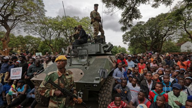 Army soldiers stand guard as protesters on Saturday demanded President Robert Mugabe stands down.