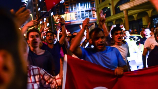Supporters of Turkish President Recep Tayyip Erdogan march in the main streets of Istanbul, in the early morning hours of Saturday.