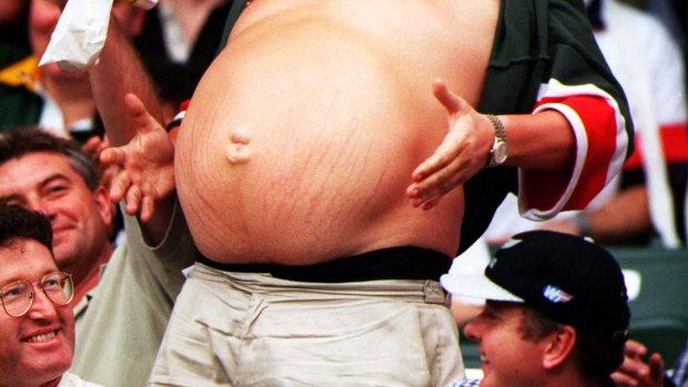 Fat: a man shows his belly at a sports match.