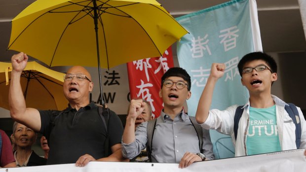 From right, pro-democracy leaders Joshua Wong, Nathan Law and legistlator Albert Chan, shout slogans outside a district court in Hong Kong in June.