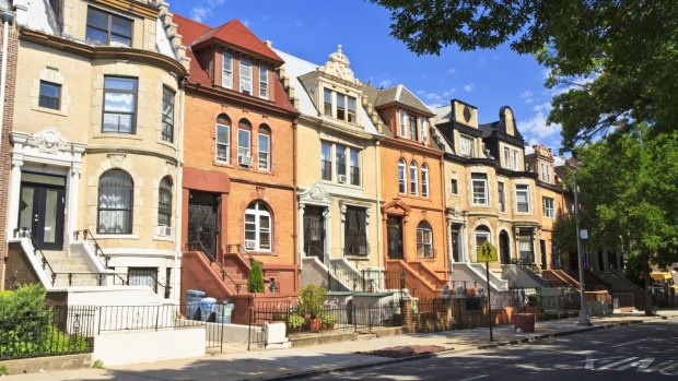 A row of unique townhouse apartment buildings with stoops on New York Ave.