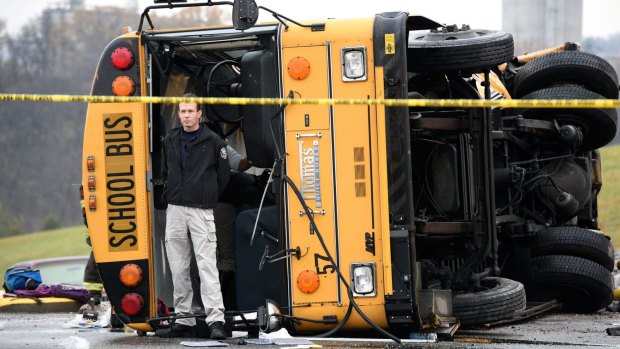 Tragic collision ... A man stands in front of one of two buses involved in the fatal accident in Knoxville, Tennessee.