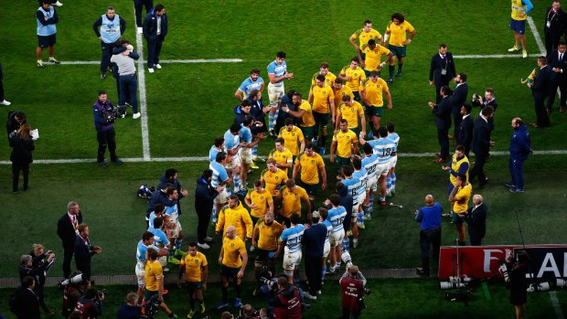 Guard of honour: The victorious Wallabies players are applauded off the field by the Argentinians.