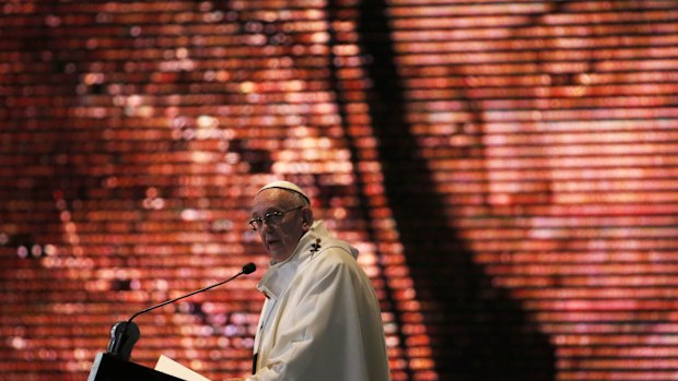 Pope Francis celebrates Mass at the Basilica of the Virgin of Guadalupe, her image is displayed behind him, in Mexico City.