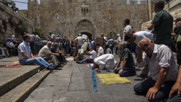 Palestinians pray outside the Lions' Gate in Jerusalem's occupied Old City on Friday.