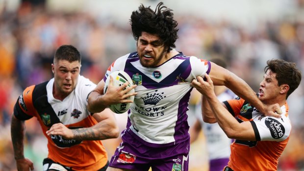 Tohu Harris of the Storm threatens the Tigers line as Mitchell Moses tries to bring him down.