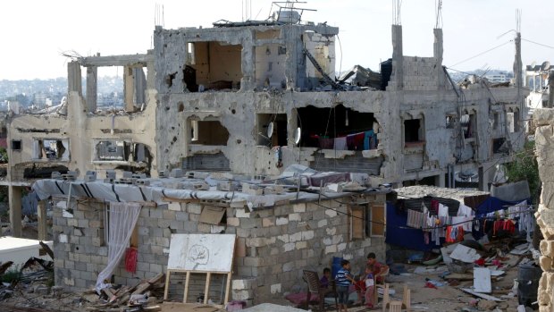 Palestinian children play near the remains of their house on Monday in Gaza City. The house was destroyed during the 50-day war between Israel and Hamas-militants in 2014. 