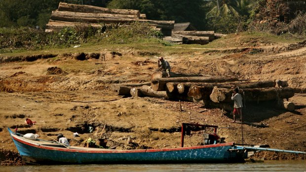 Men working with logs on the banks of the Irrawaddy River between Bhamo and Shwegu in Kachin state, Myanmar. 