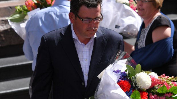 Premier Daniel Andrews lays flowers in the Bourke Street Mall on Saturday morning. 