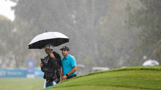 Sergio Garcia waits in the rain on Thursday.