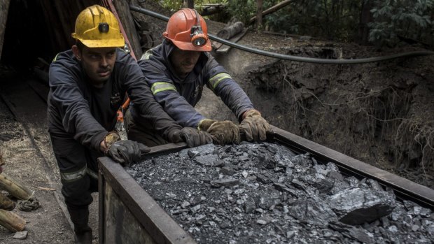 Colombian coal miners push a wagon of coal: Campaign seeks to urge more nations to cut use of the fossil fuel.