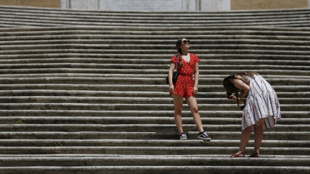 Tourists take photos at the Spanish Steps in Rome in June after the government removed its masks outdoors rules.