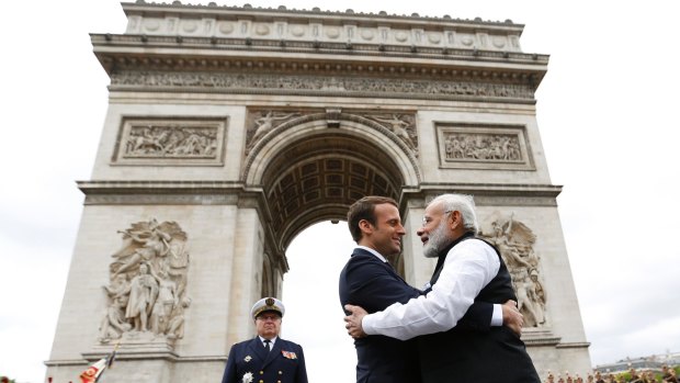 French President Emmanuel Macron hugs Indian PM Narendra Modi at the Arc de Triomphe in Paris on Saturday. The two discussed fighting climate change.