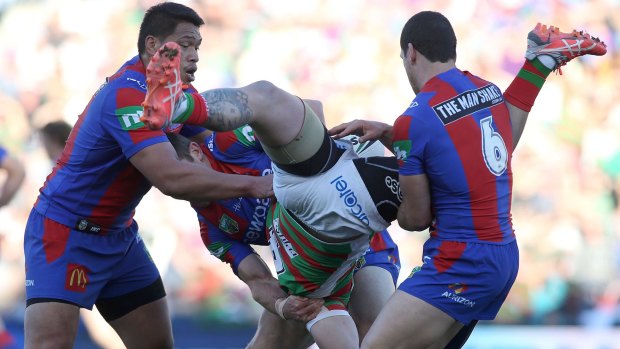 Awkward landing: Aaron Gray of the Rabbitohs is tackled by the Knights defence.