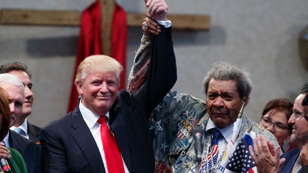 Boxing promoter Don King holds up the hand of Republican presidential candidate Donald Trump during a visit to the Pastors Leadership Conference at New Spirit Revival Centre on Wednesday.