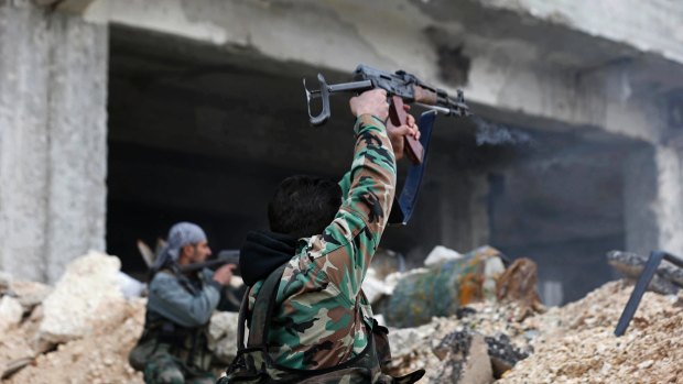Syrian army soldiers fire their weapons during a battle with rebel fighters at the Ramouseh front line, east of Aleppo, on Monday.