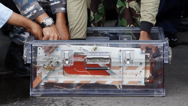The flight data recorder from AirAsia QZ8501 is placed into a container upon its arrival at the airbase in Pangkalan Bun, Central Kalimantan.