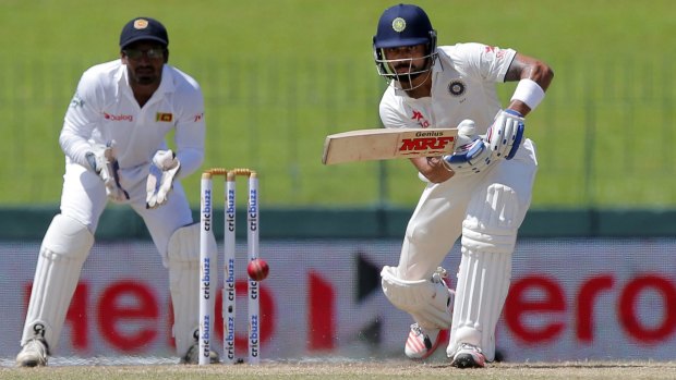 India's captain Virat Kohli lunges forward at a delivery as Sri Lanka's wicket keeper Kusal Janith Perera watches.