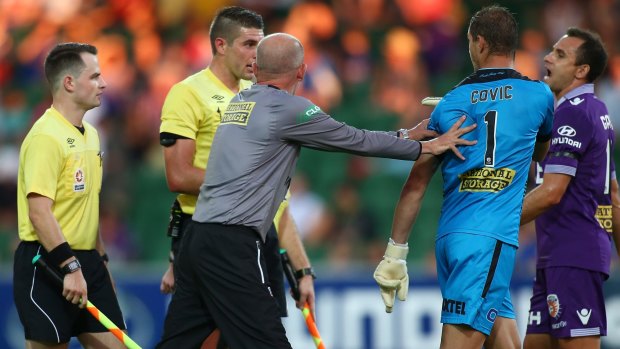 Keeping the peace:  Perth Glory coach Kenny Lowe attempts to defuse a row between goalkeeper Ante Covic and referee Shaun Evans.