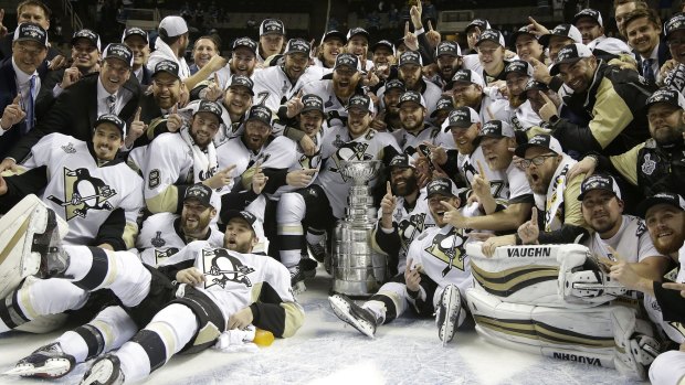 Heaven on ice: Pittsburgh Penguins players and coaches pose for photos with the Stanley Cup.