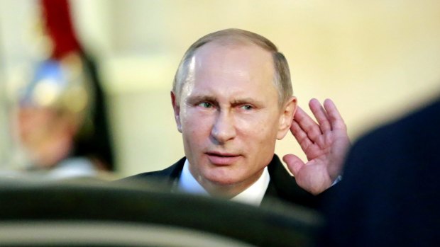 Not listening: Russian President Vladimir Putin tries to hear a reporter's question as he leaves the Elysee Palace in Paris on Friday.