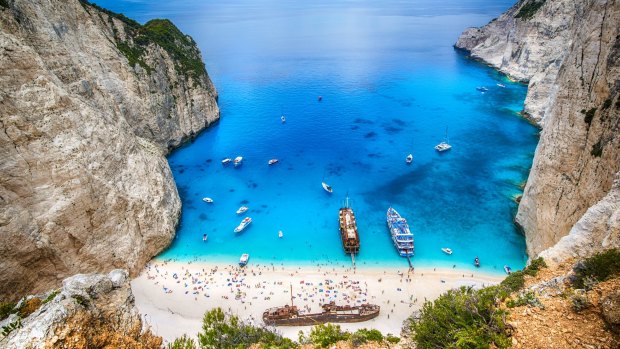 Tourists and tourist boats  in the famous Navagio Bay on Greece's Zakynthos island.