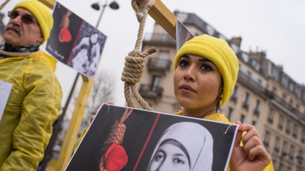Demonstrators pose with a symbolic rope around their necks as Iranian opposition protesters march during a rally against executions in Iran during Iranian President Hassan Rouhani's visit to Paris.