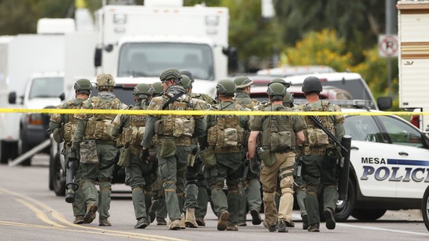 A SWAT team searches for the gunman in Mesa, Arizona.