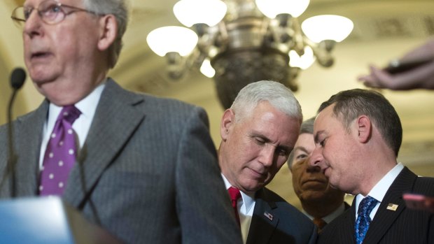 Vice President-elect Mike Pence speaks with Reince Priebus, chief of staff for President-elect Donald Trump, right, as Senate Majority Leader Mitch McConnell speaks at a news conference  in Washington.