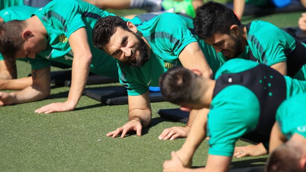 Welcome return: Mile Jedinak stretches during a Socceroos training session in Canberra.