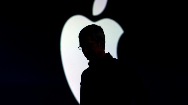 The silhouette of Tim Cook, chief executive officer of Apple, is seen as he exits the stage during an Apple event.