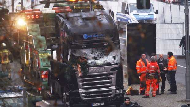 Security and rescue workers stand next to a truck which ploughed into a market in Berlin on December 20.